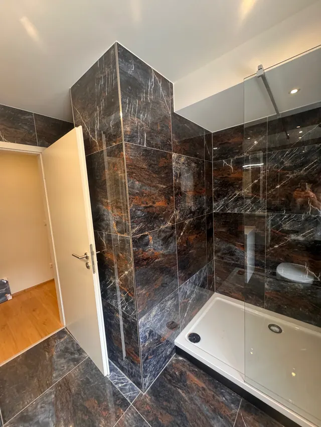 Bodengleiche Dusche mit dunklen Marmorfliesen