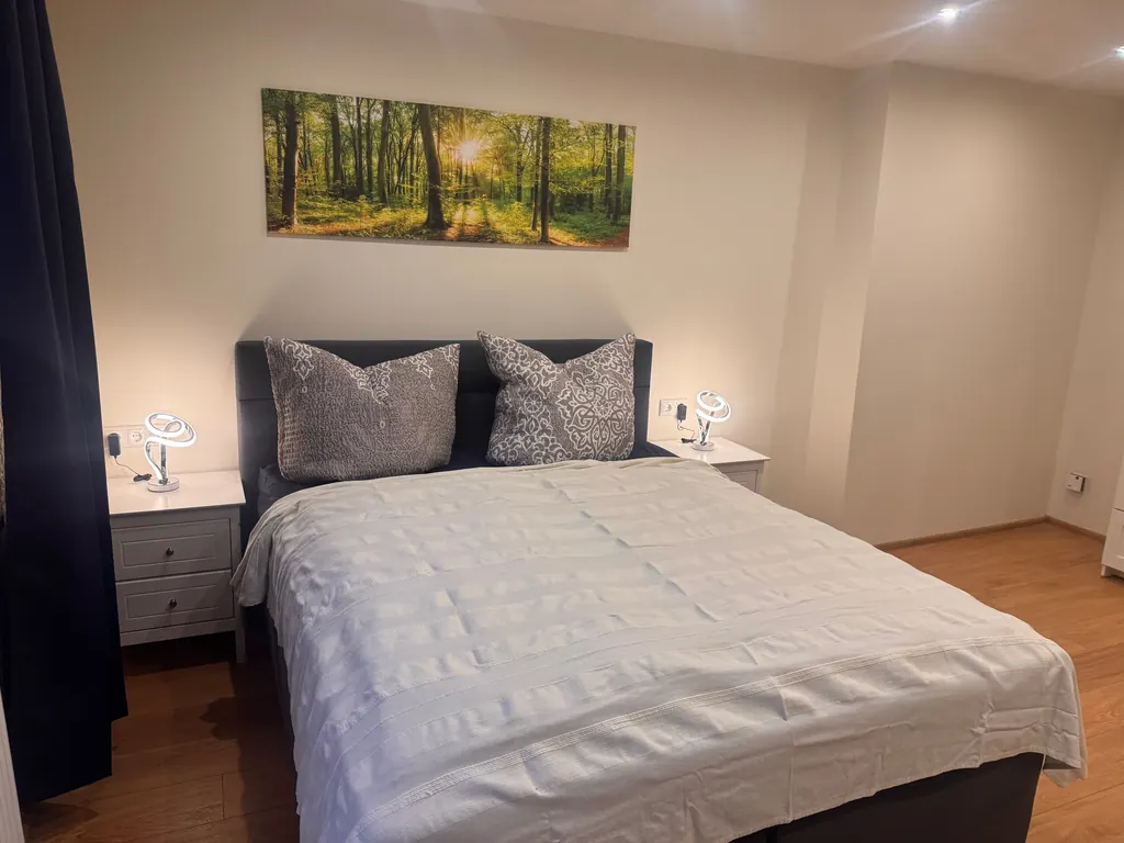 Schlafzimmer mit Doppelbett und Landschaftsbild
